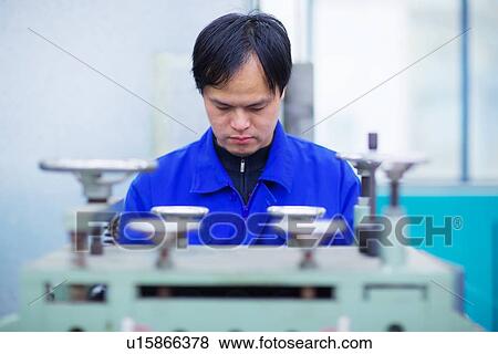 Worker at small parts manufacturing factory in China, looking down View Large Photo Image Stock Photo - Worker at small parts manufacturing factory in China, looking down. Fotosearch