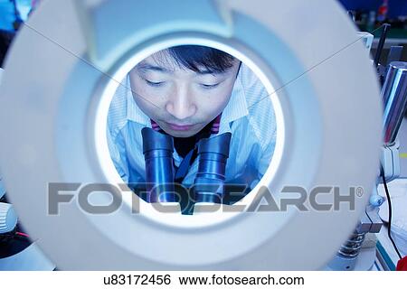 Worker at small parts manufacturing factory in China looking through microscope View Large Photo Image Stock Photograph - Worker at small parts manufacturing factory in China looking through microscope. Fotosearch