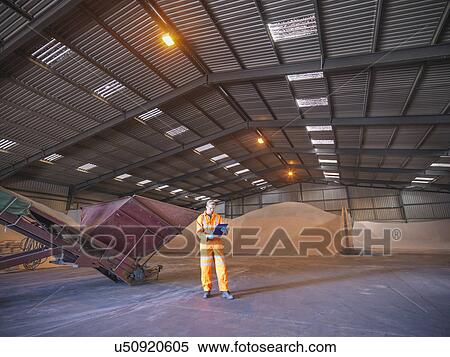 Worker checking clipboard in warehouse with zircon sand View Large Photo Image Stock Photography - Worker checking clipboard in warehouse with zircon sand. Fotosearch