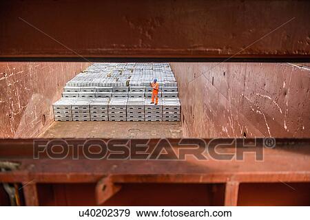 Worker checking metal ingots in ship's hold View Large Photo Image Stock Photo - Worker checking metal ingots in ship's hold. Fotosearch