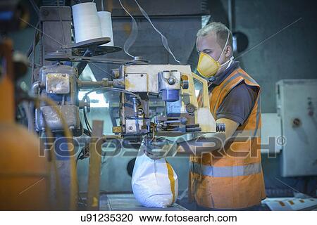 Worker in protective clothing filling bag with minerals View Large Photo Image Stock Image - Worker in protective clothing filling bag with minerals. Fotosearch