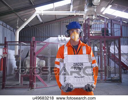 Worker in protective clothing holding zircon flour bag in mill View Large Photo Image Stock Photo - Worker in protective clothing holding zircon flour bag in mill. Fotosearch