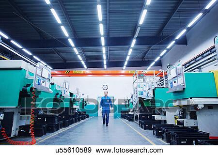 Stock Photo - Worker walking through small parts manufacturing factory in China. Fotosearch