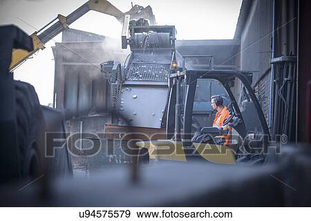 Worker watching machinery crush titanium metal View Large Photo Image Stock Photo - Worker watching machinery crush titanium metal. Fotosearch