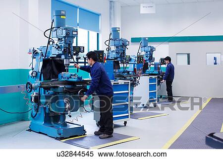 Stock Photography - Workers at small parts manufacturing factory in China. Fotosearch