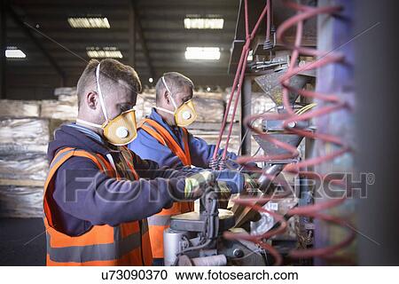 Workers in protective clothing filling bags with minerals View Large Photo Image Stock Image - Workers in protective clothing filling bags with minerals. Fotosearch