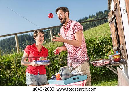 Stock Photo - Young couple fooling around outside chalet, Tyrol, Austria. Fotosearch
