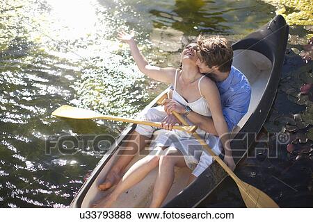 Young couple hugging in rowing boat View Large Photo Image Stock Photo - Young couple hugging in rowing boat. Fotosearch