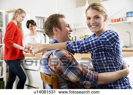 Young couple in kitchen with woman and teenage girl View Large Photo Image Stock Image - Young couple in kitchen with woman and teenage girl. Fotosearch