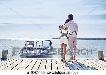 Stock Photo - Young couple on pier looking at view, Gavle, Sweden. Fotosearch
