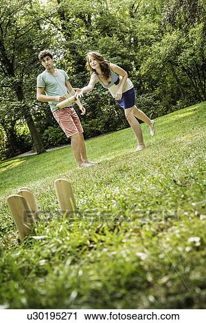 Young couple playing Molkky in park View Large Photo Image Stock Image - Young couple playing Molkky in park. Fotosearch
