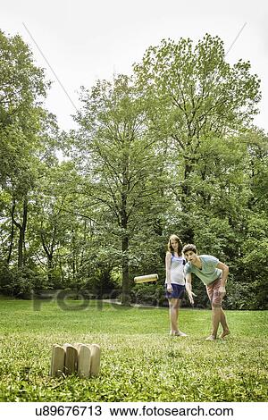 Young couple playing Molkky in park View Large Photo Image Stock Image - Young couple playing Molkky in park. Fotosearch
