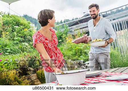 Stock Image - Young couple preparing picnic lunch, Tyrol, Austria. Fotosearch