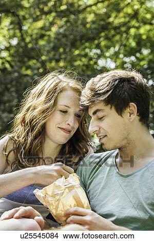 Young couple sharing bag of food View Large Photo Image Picture - Young couple sharing bag of food. Fotosearch