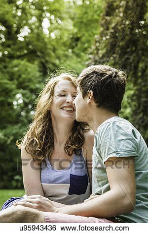 Young couple sitting in park View Large Photo Image Stock Photograph - Young couple sitting in park. Fotosearch