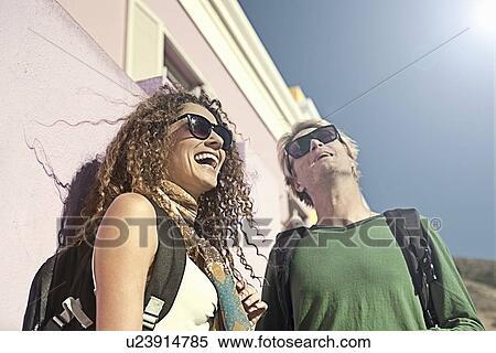 Young couple standing outside of painted house, looking up and laughing View Large Photo Image Stock Photography - Young couple standing outside of painted house, looking up and laughing. Fotosearch