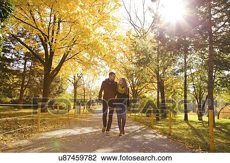 Young couple strolling in autumn park, Vienna, Austria View Large Photo Image Stock Image - Young couple strolling in autumn park, Vienna, Austria. Fotosearch
