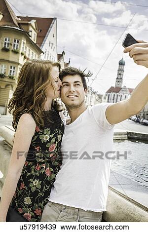 Stock Photo - Young couple taking self portrait photograph. Fotosearch