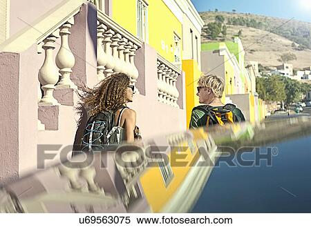 Young couple walking past pastel painted houses View Large Photo Image Stock Photography - Young couple walking past pastel painted houses. Fotosearch