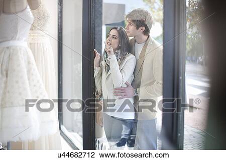 Young couple window shopping, looking through shop front View Large Photo Image Stock Image - Young couple window shopping, looking through shop front. Fotosearch