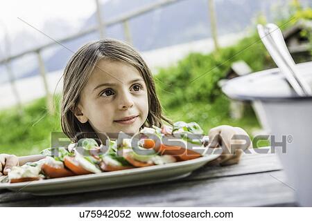 Young girl holding salad plate for picnic lunch, Tyrol, Austria View Large Photo Image Stock Image - Young girl holding salad plate for picnic lunch, Tyrol, Austria. Fotosearch