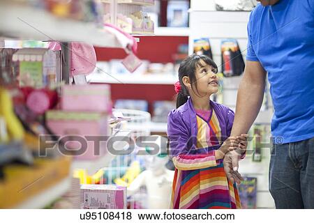 Young girl pleading with father in toy shop View Large Photo Image Stock Photo - Young girl pleading with father in toy shop. Fotosearch
