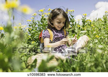 Young girl sitting in field View Large Photo Image Stock Image - Young girl sitting in field. Fotosearch