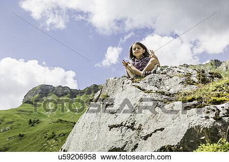 Young girl sitting on rocks, Tyrol, Austria View Large Photo Image Stock Photo - Young girl sitting on rocks, Tyrol, Austria. Fotosearch