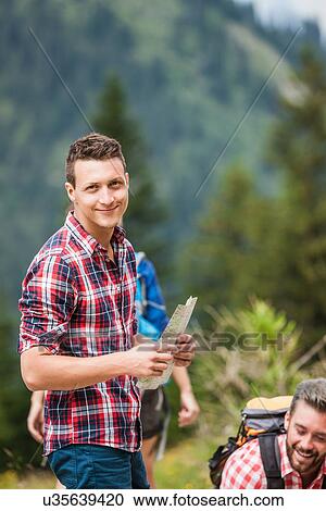 Stock Image - Young man with map, Tyrol, Austria. Fotosearch