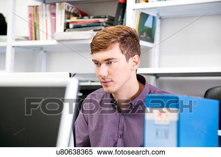 Young man working in office View Large Photo Image Stock Photography - Young man working in office. Fotosearch