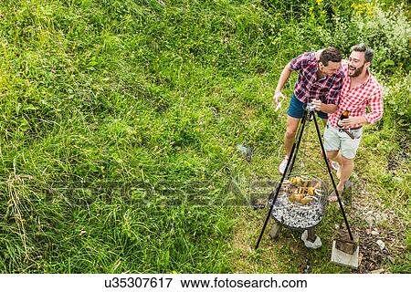Young men having fun barbecuing lunch View Large Photo Image Stock Photo - Young men having fun barbecuing lunch. Fotosearch