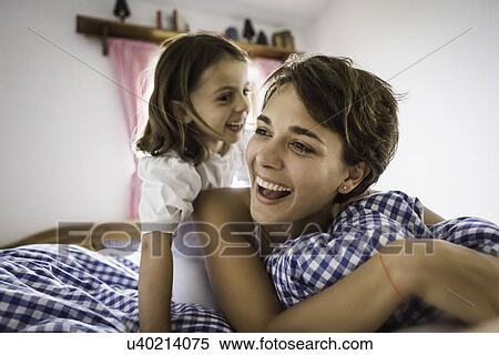 Young woman and daughter on bed in holiday chalet, Tyrol, Austria View Large Photo Image Stock Photography - Young woman and daughter on bed in holiday chalet, Tyrol, Austria. Fotosearch