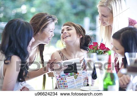 Picture - Young woman and friends with picture frame. Fotosearch