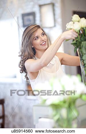Young woman arranging roses in vase View Large Photo Image Stock Image - Young woman arranging roses in vase. Fotosearch