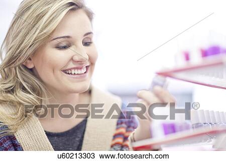 Young woman choosing nail polish View Large Photo Image Stock Image - Young woman choosing nail polish. Fotosearch