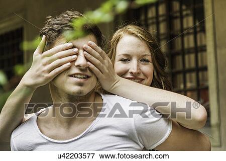 Young woman covering boyfriend's eyes View Large Photo Image Stock Photo - Young woman covering boyfriend's eyes. Fotosearch