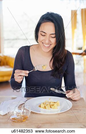 Young woman enjoying meal in restaurant View Large Photo Image Stock Image - Young woman enjoying meal in restaurant. Fotosearch