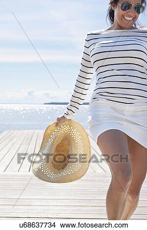 Young woman holding sunhat View Large Photo Image Picture - Young woman holding sunhat. Fotosearch