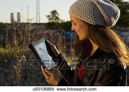 Stock Photography - Young woman looking at digital tablet screen. Fotosearch