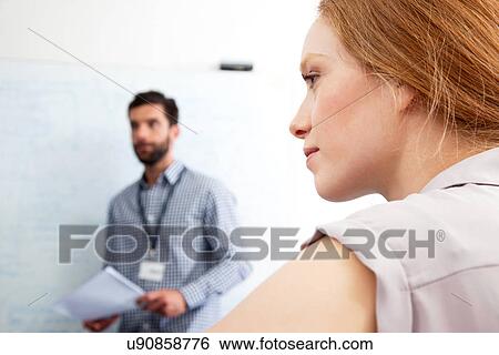 Stock Photograph - Young woman looking away in business meeting. Fotosearch
