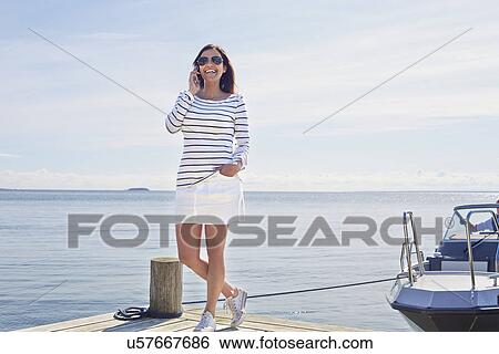 Young woman on cell phone on pier, Gavle, Sweden View Large Photo Image Stock Photograph - Young woman on cell phone on pier, Gavle, Sweden. Fotosearch