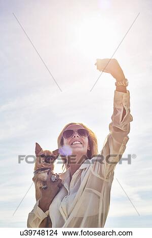 Young woman photographing herself with dog View Large Photo Image Picture - Young woman photographing herself with dog. Fotosearch