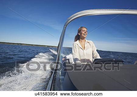 Picture - Young woman steering boat, Gavle, Sweden. Fotosearch