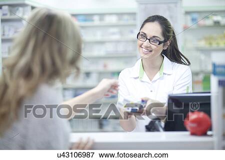 Stock Photo - Young woman talking to pharmacist. Fotosearch