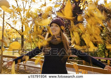 Young woman throwing up autumn leaves in park View Large Photo Image Picture - Young woman throwing up autumn leaves in park. Fotosearch