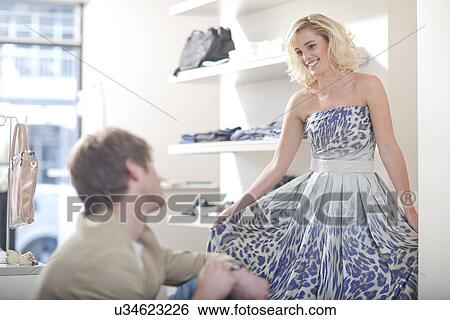 Young woman trying on dress View Large Photo Image Stock Photograph - Young woman trying on dress. Fotosearch
