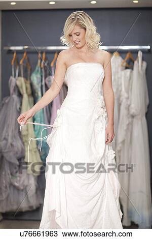Young woman trying on wedding dress View Large Photo Image Stock Image - Young woman trying on wedding dress. Fotosearch