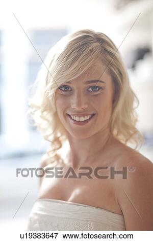 Stock Photo - Young woman trying on wedding dress. Fotosearch