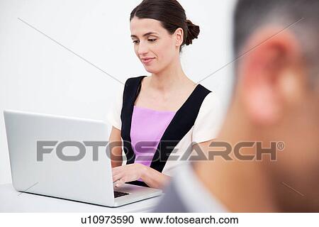 Stock Image - Young woman using laptop. Fotosearch