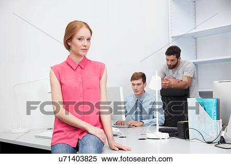 Stock Photography - Young woman wearing pink blouse in office. Fotosearch